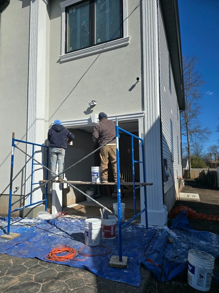 Equipo trabajando en andamios en instalación de estuco